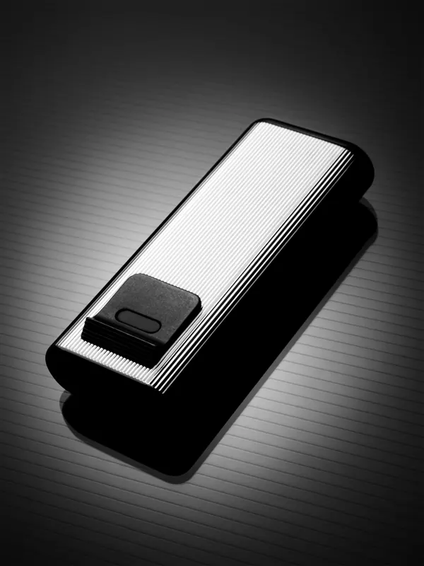 Unmarked slim black-and-silver pocket lighter with a ribbed face and dark rectangular control